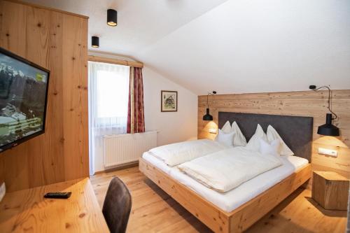 斯拉德明Urlpoldhof的一间带大床和电视的卧室