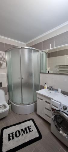 bagno con doccia, servizi igienici e tappeto di Квартира в центре города со всеми удобствами a Chmel'nyc'kyj