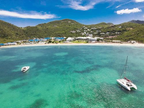 Dos barcos en el agua cerca de una playa en Case à Sucre Peaceful retreat with sea view and beach direct access, en Anse Marcel 