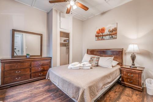 ein Schlafzimmer mit einem Bett mit einer Kommode und einem Spiegel in der Unterkunft The Vance Corner Suite - Bright and Relaxing in Memphis