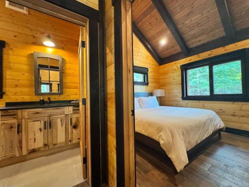 a bedroom with a bed in a wooden cabin at Mountaineer Creekside Cabin - Private Hot Tub in Golden