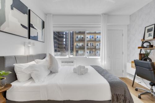 a white bed in a room with a window at The Sherbrooke Suite 99 in Montreal