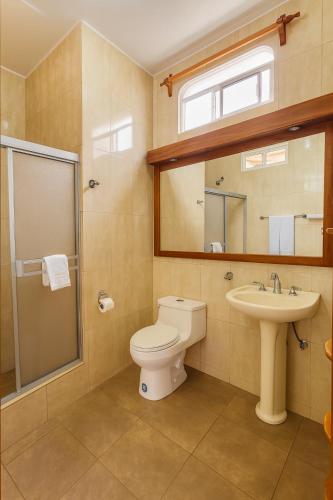 a bathroom with a toilet and a sink at Hotel Del Sol Galapagos in Puerto Ayora