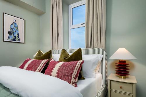 Un dormitorio con una cama blanca con almohadas y una ventana. en Modern 1-Bed Retreat by Stirling Train Station, en Stirling