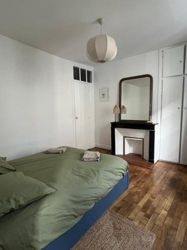 a bedroom with a bed with a mirror and a fireplace at L'Ecrin Bellifontain - Appartement Confort - Centre in Fontainebleau