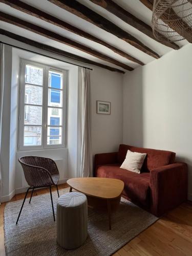 a living room with a couch and a table at L'Ecrin Bellifontain - Appartement Confort - Centre in Fontainebleau