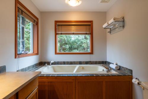 eine Badewanne im Bad mit Fenster in der Unterkunft Chesterman on the Point - Beachfront in Tofino