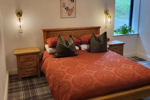 a bedroom with a red bed with pillows on it at 3 Bed House - Sea Views Balcony Parking Pets in Innellan