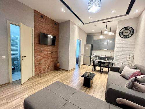 Una sala de estar con un sofá y una cocina. en Rustaveli Modern Apartment Center of Tbilisi, en Tiflis