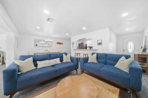 a living room with two blue couches at Manatee Cove Waterfront Home w Dock Pool in Cocoa Beach