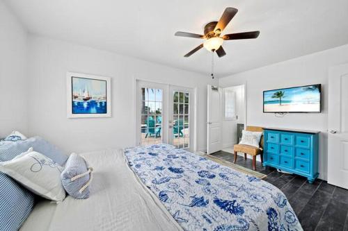 a bedroom with a bed and a ceiling fan at Manatee Cove Waterfront Home w Dock Pool in Cocoa Beach