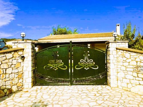 a green gate in a stone wall at Villa Spiti Ute in Makrádes