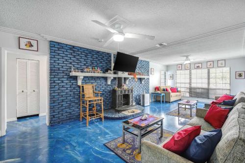 a living room with blue flooring and a fireplace at The Leon Lane Oasis w Pool Fire Pit Steps to the Beach in Cape Canaveral