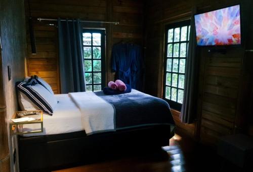 a bedroom with a bed with a teddy bear on it at Floresta das Evas in Petrópolis