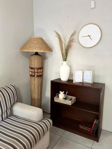 a living room with a lamp and a chair at De Valk & Tak Manor in Bloemfontein
