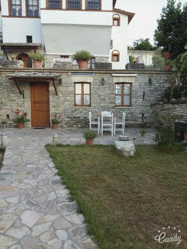 a stone house with a table and chairs in the yard at Hotel Gjirokastra in Gjirokastër