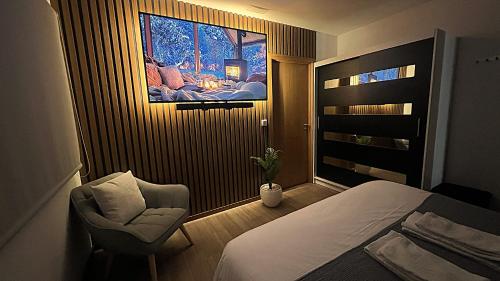 a bedroom with a bed and a chair and a window at TOURAL HOUSE Villa in Arcos de Valdevez