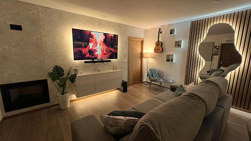 a living room with a couch and a tv at TOURAL HOUSE Villa in Arcos de Valdevez