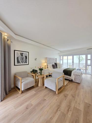 White Cottage Boutique Guesthouse في سواكوبموند: غرفة معيشة كبيرة مع سرير وأريكة