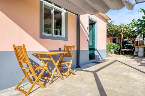 two chairs and a table outside of a house at O Miminho, a Home in Madeira in São Jorge