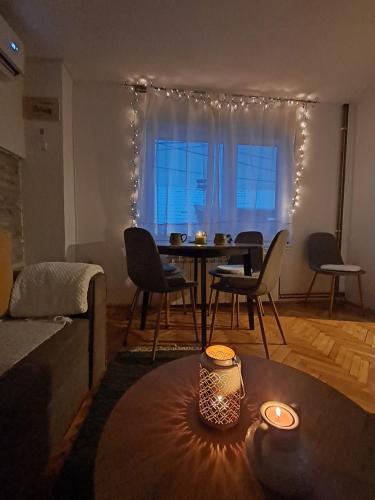 萨拉热窝Sarajevo Cozy Attic - Free Parking的一间带桌椅的客厅和一间用餐室