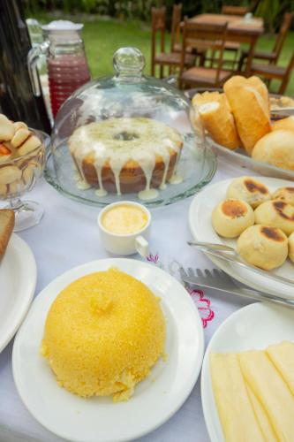 un tavolo sormontato da piatti di torte e pasticcini di Pousada Raízes da Mata a Santa Cruz Cabrália