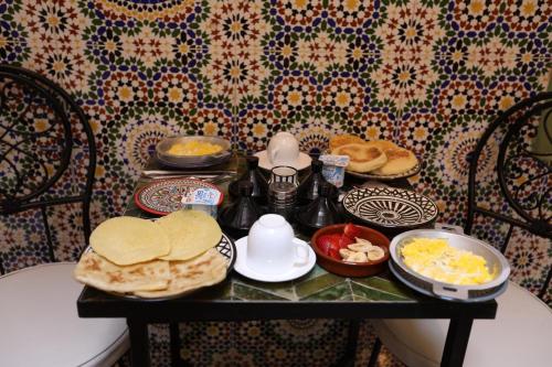 a table with breakfast foods and eggs on it at Riad dar lfen Chambre twin in Marrakech