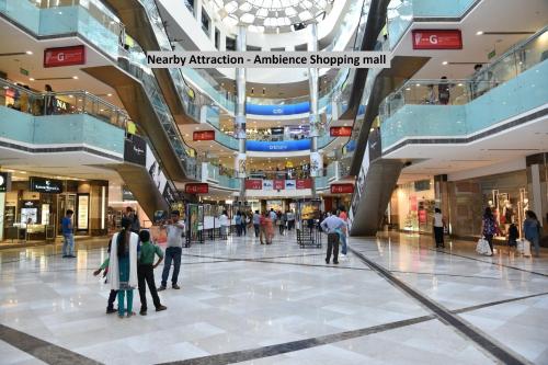 a shopping mall with people walking in it at Capital O Levanti Near Aravali Biodiversity Park in Gurgaon