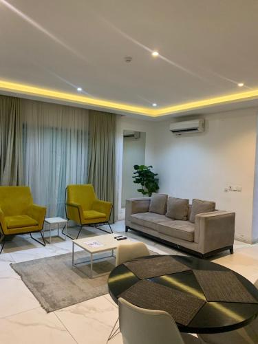 salon z kanapą, krzesłami i stołem w obiekcie The Pelican Lagos w mieście Badore