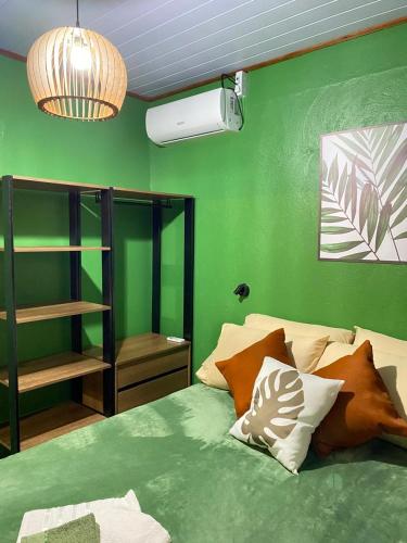 a bedroom with green walls and a bed with pillows at Casa das Oliveiras in Torres