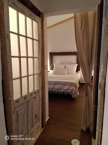 a bedroom with a bed and a large window at Casa do Adro in Corte do Gafo de Cima