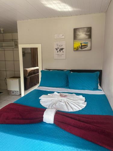 een slaapkamer met een bed en een badjas. bij Buena Onda Suites in Abraão