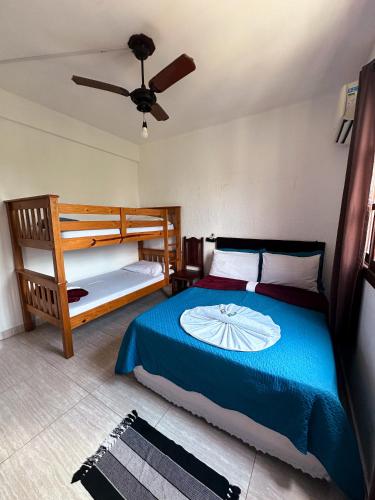 a bedroom with a bed and two bunk beds at Buena Onda Suites in Abraão