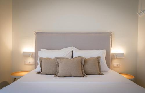a bed with a white headboard and three pillows at Villa Artemis 3 - Etheras Properties in Diakofti