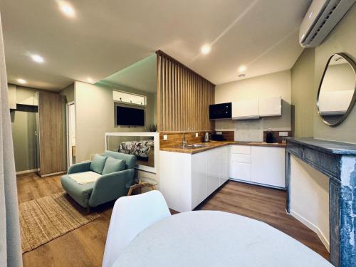 a kitchen with a couch and a chair in a room at Demeure BelPel - Appartement Daurel in Bessan