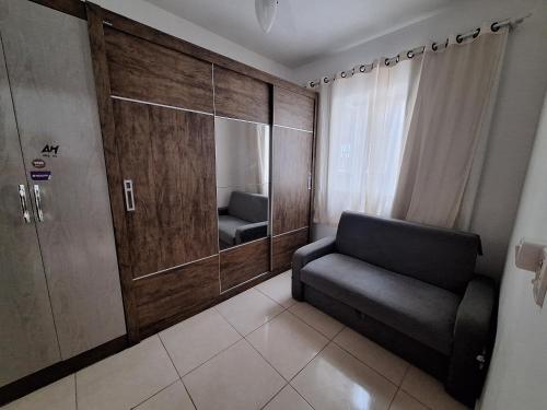 een woonkamer met een stoel en een grote spiegel bij Casa da Vo da Maria pertinho do mar in Matinhos