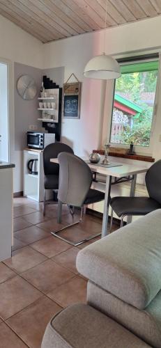 eine Küche und ein Wohnzimmer mit Tisch und Stühlen in der Unterkunft Ferienhaus Sonneneck mit Motorboot und Kanu in Basedow