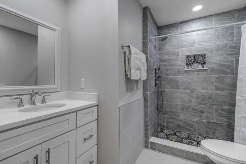a white bathroom with a sink and a shower at Belle Vue - Modern condo near beach w golf views in Ponte Vedra Beach