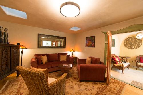a living room with a brown couch and chairs at The Emerald Iguana Inn in Ojai