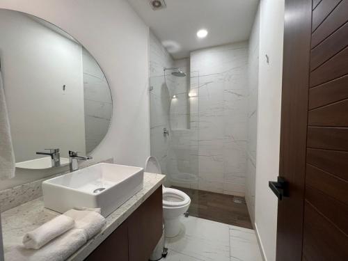 a bathroom with a sink and a toilet and a mirror at Place in the Romantic Zone with a Rooftop 301 in Puerto Vallarta