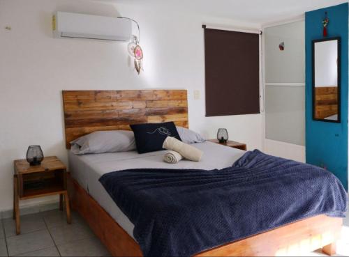 Un dormitorio con una cama grande con una manta azul. en Equipped Yaxkin Studio on downtown, 3 blocks away from sea, close to restaurants, en Cozumel