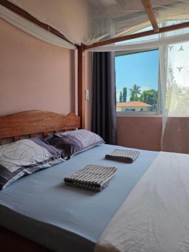 迪亚尼海滩CASA BOUGAN APARTMENTS的一间卧室配有一张床,上面设有两个键盘