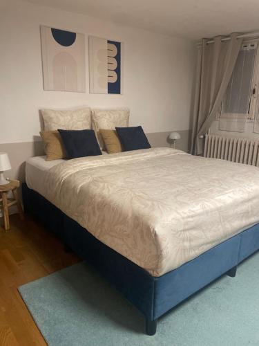 uma cama grande em um quarto com uma estrutura azul em Chambre avec SDB privé em Montpellier
