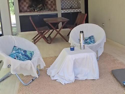 two white chairs and a table and a table with a laptop at Casa XIII in Costa del Este