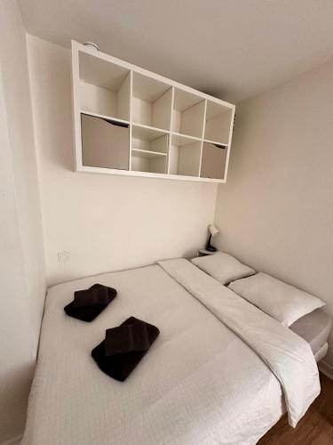 ein Schlafzimmer mit einem großen weißen Bett mit zwei Kissen in der Unterkunft Instant Emeraude Apartment in Saint-Brieuc