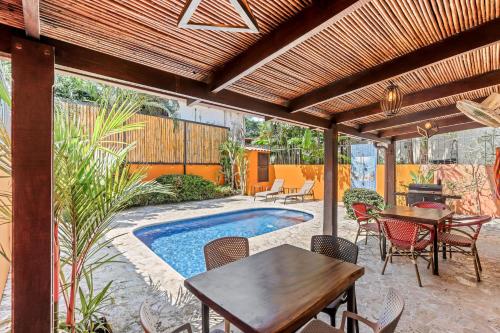 eine Terrasse mit Tisch und Stühlen und einem Pool in der Unterkunft Charming Duplex in Playa Potrero Surfside Community, with a Private Pool, Cozy Interior and Walkable Access to the Beach in Potrero