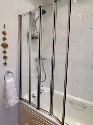 a shower with glass doors in a bathroom at The Cotton Mill Hideaway - One Bedroom Apartment - Free Parking near Etihad Stadium & CoOp Live in Manchester