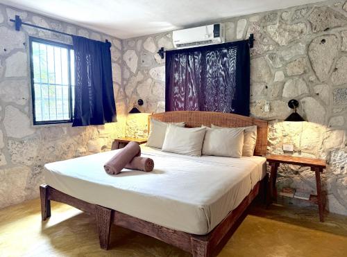 a bedroom with a bed with a teddy bear on it at Hostel Oryx Tulum in Tulum