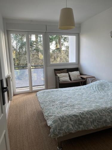 una camera da letto con un letto, un divano e finestre di Charmant appartement centre a Laval