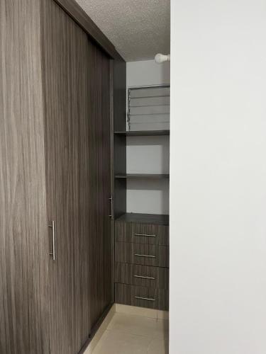 a walk in closet with wooden doors and shelves at Apartamento amoblado en parque heredia in Cartagena de Indias